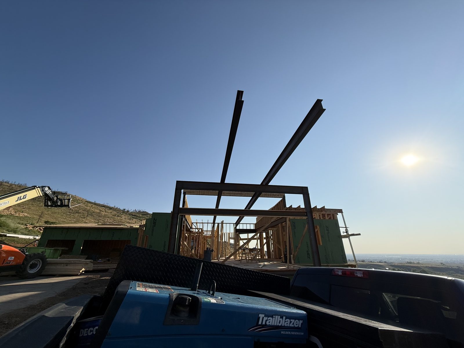 Structural steel beams craned into position against an open sky on a custom residential build