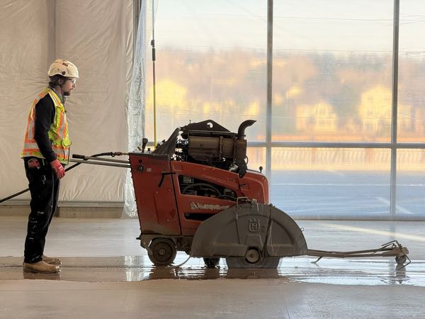 Straight wet-cut trench lines through a tilt-up warehouse slab